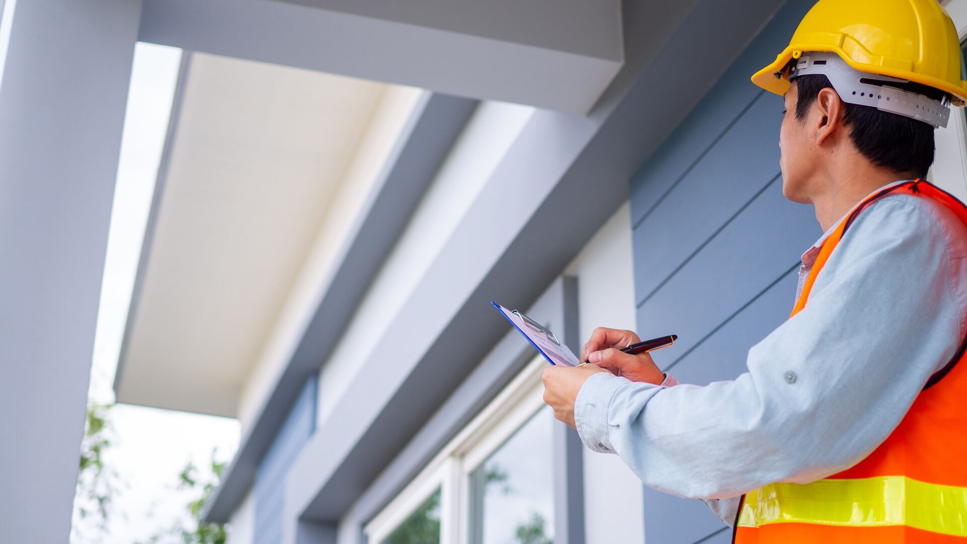 Boundary encroachment inspector checking building structure measurements on site